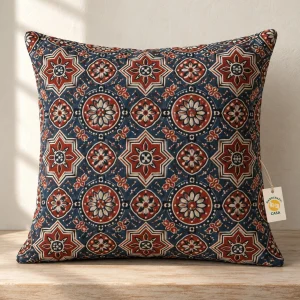 Ajrakh-style rust, indigo and ivory patterned cushion cover with a removable Casa paper tag.