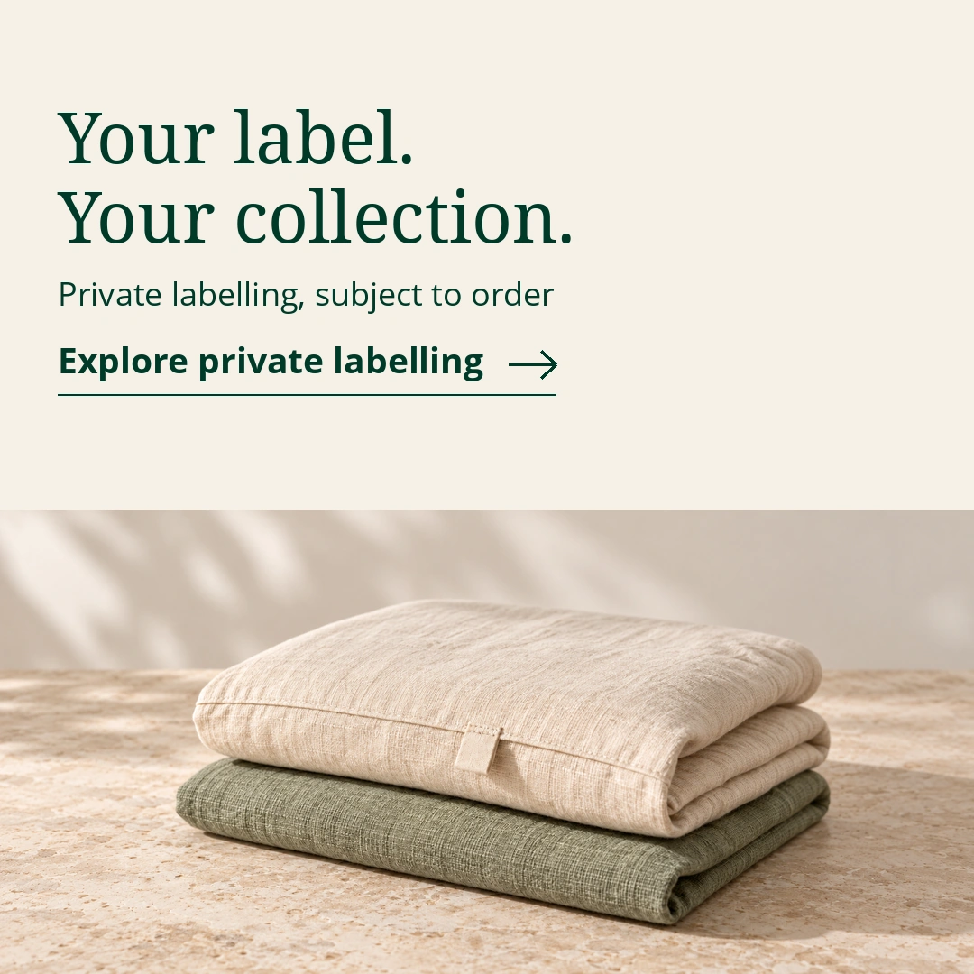 Your label. Your collection. Private labelling, subject to order. Explore private labelling. Illustrative folded ivory and sage home textiles with a blank sewn fabric label.