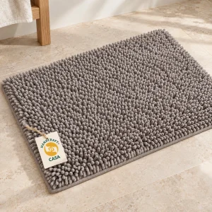 Grey chenille bath mat with a removable Casa presentation tag.