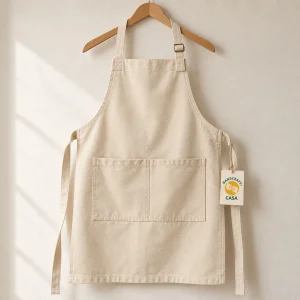Natural-coloured cotton canvas bib apron with a front pocket, adjustable neck strap and removable Casa tag.