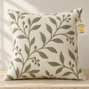 Cotton cushion cover with green embroidered leafy branches and a removable Casa paper tag.