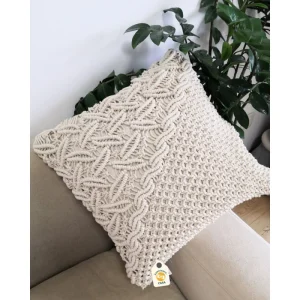 Cream cushion cover with raised diamond and grid-like textures on a grey seat.