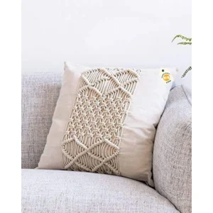 Cream cushion cover with a raised geometric strip on a light-grey sofa.
