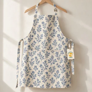 Blue floral printed cotton apron on a wooden hanger with a removable Casa paper tag.