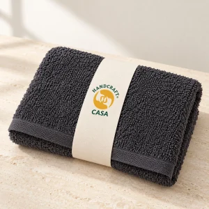Folded dark salon and spa hand towel with a removable Casa paper band.