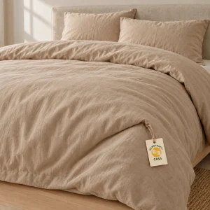 Taupe stonewashed cotton duvet cover on a bed with a removable Casa presentation tag.