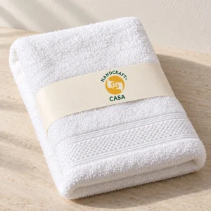Folded white hotel hand towel with a removable Casa paper band.