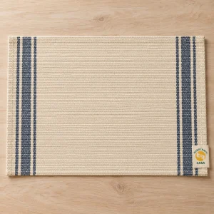 Cream woven cotton placemat with blue side stripes and a Casa paper presentation tag.