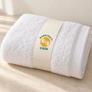 Folded white zero twist bath towel with a removable Casa paper band.
